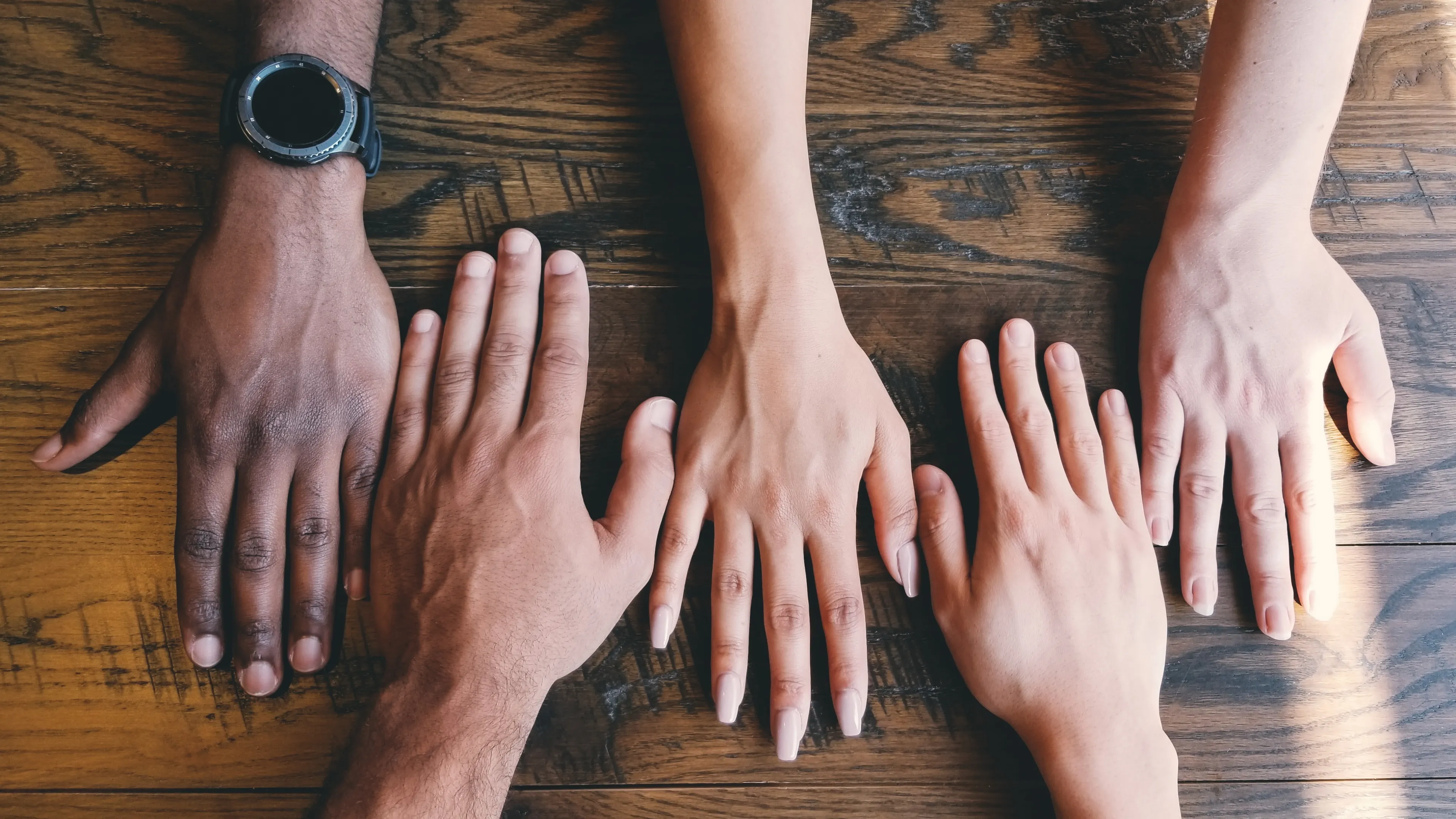 Hands reaching across table.
