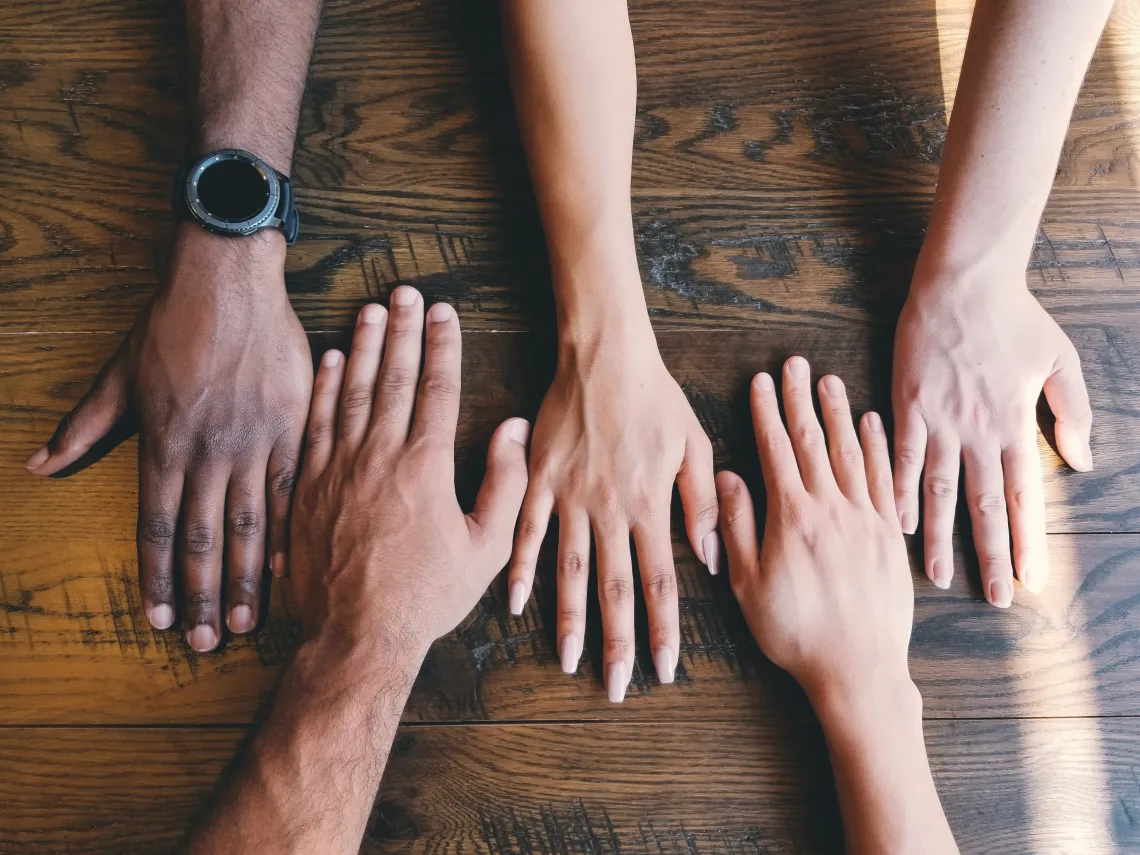 Hands reaching across table. 